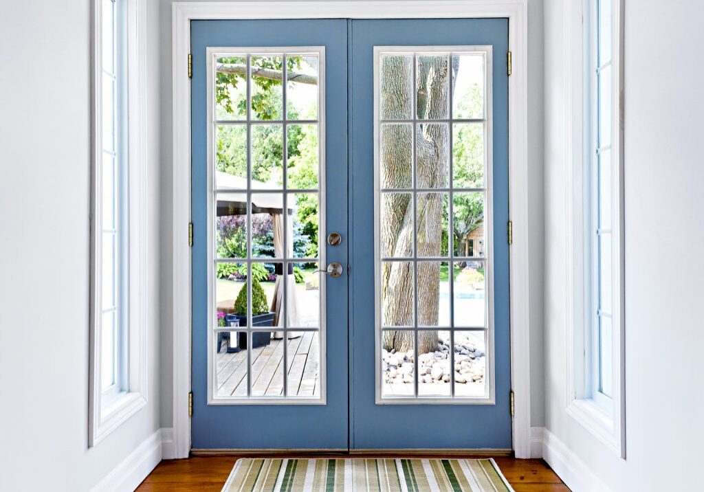 Double patio french doors with windows exiting to sunny backyard